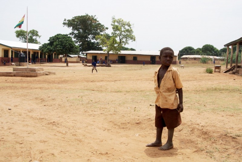 Boy stands outside school in Ghana