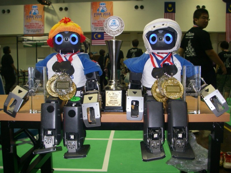 Small humanoid robots wearing gold medals