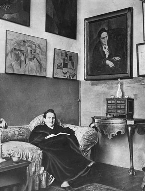 Gertrude Stein at her Paris apartment. Picasso's cubist portrait of her hangs on the wall to the right.