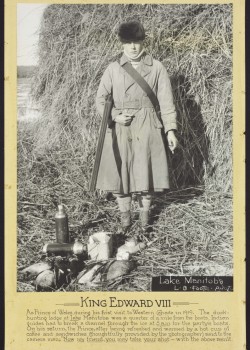 Edward VIII, Prince of Wales, stands by Delat Marsh, a gun slung across the crook of his right arm, his left arm holds a cigarette. Canteens lay at his feet. he had just returned from a hunt. 