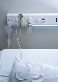 illness concept image of bed with emergency health equipment panel above