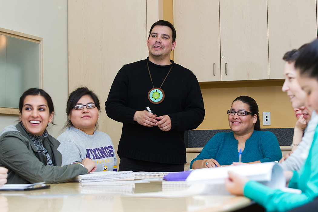Niigaan Sinclair (standing), associate professor and graduate program director in the department of Native Studies, engages his class in lively discussion.