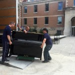 Movers carry one of the Desautels Faculty of Music's many pianos into Taché Hall 