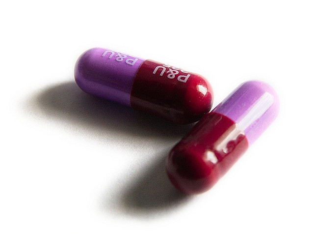 Two pink pills on a white table