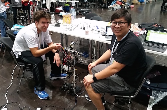 U of M's Kyle Morris (L) and Meng Cheng Lau prepare a robot for the technical challenge, which they took first place in.