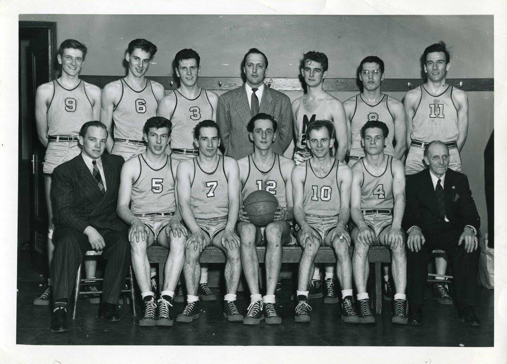A photograph, dated February 13, 1948, taken in Saskatchewan at the Western Canadian Intercollegiate Athletic Union tournament, of the University of Manitoba Bisons basketball team. Back row (left to right): Carl Ridd, Roy Williams, Rae Tallin, Pat Twomey, Doug Cannel, Alvin Cromarty, Jay Lucas. Front (left to right): Paul DuVal, Don Reid, Bunky Templin, Clint McFarlane, Mike Spack, Eddie Pollock, Charlie Wade.<br />
Source: Faculty of Physical Education and Recreational Studies fonds