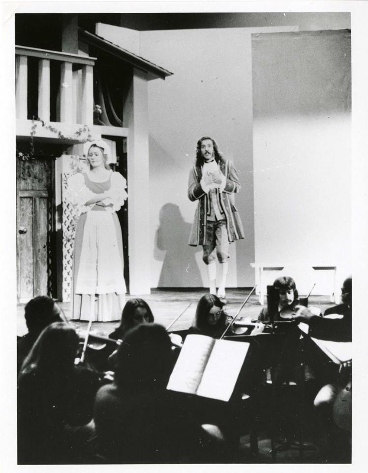 A photograph of unidentified students performing in an operetta at the University of Manitoba. A portion of the set on the stage is visible, and some of the musicians in the orchestra pit are partially visible in the photograph. Photograph is dated as having been taken around 1970.<br />
Source: University Relations & Information Office fonds