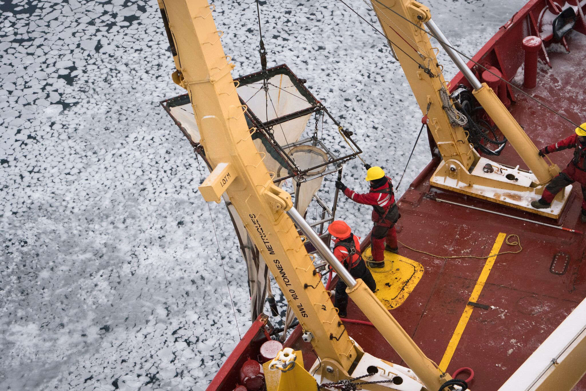 Researchers in red suits on the deck of am ice-breaking ship