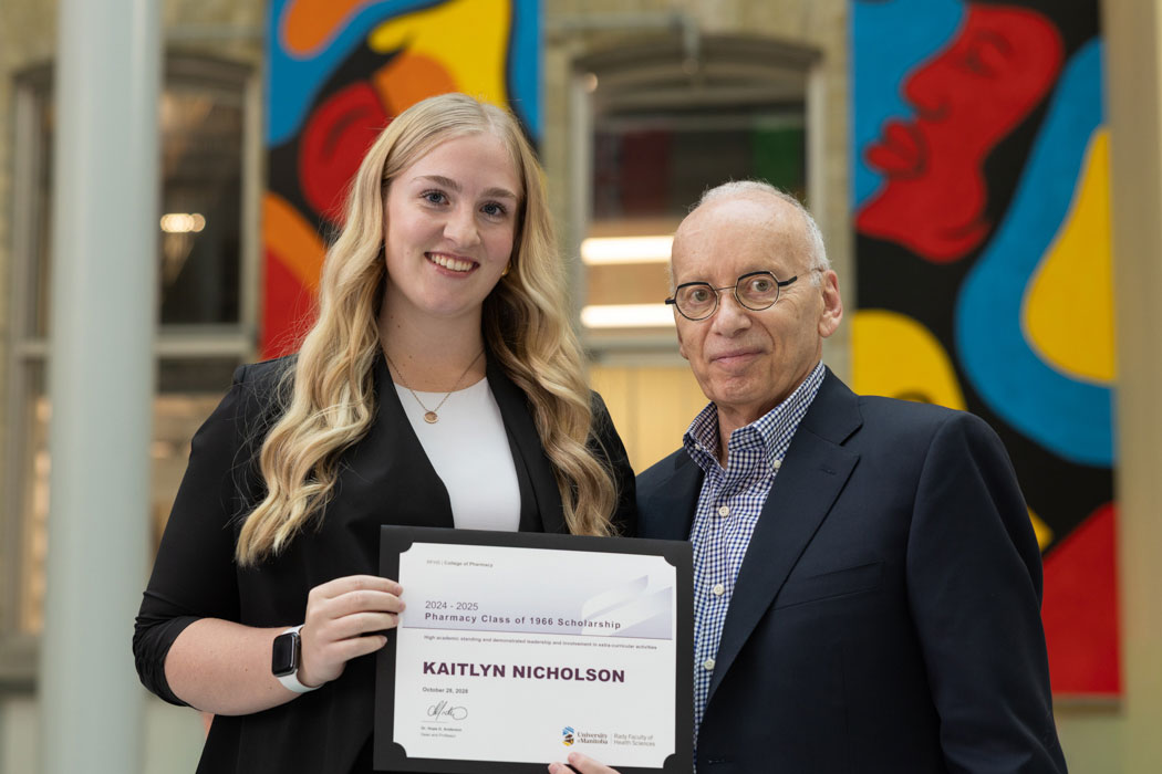 Lyle Silverman, right, presents the Pharmacy Class of 1966 Scholarship Award to Kaitlyn Nicholson, left.