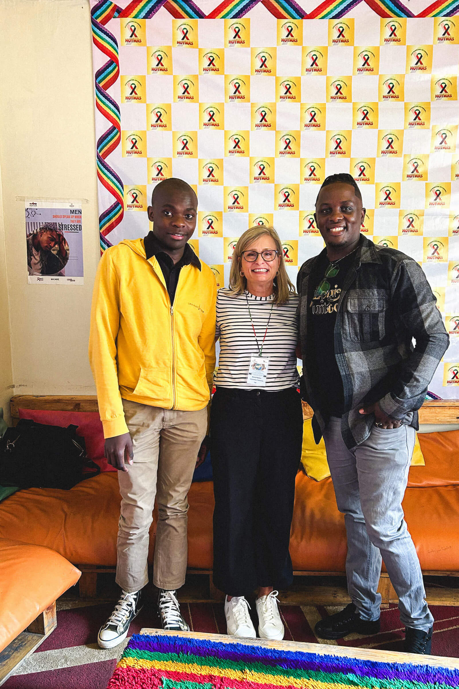 Three smiling people (two men and a woman) standing together