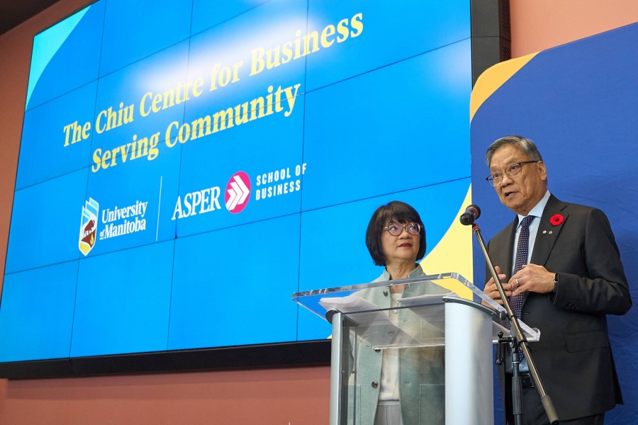 Elanor and Wayne Chiu speaking at a podium.