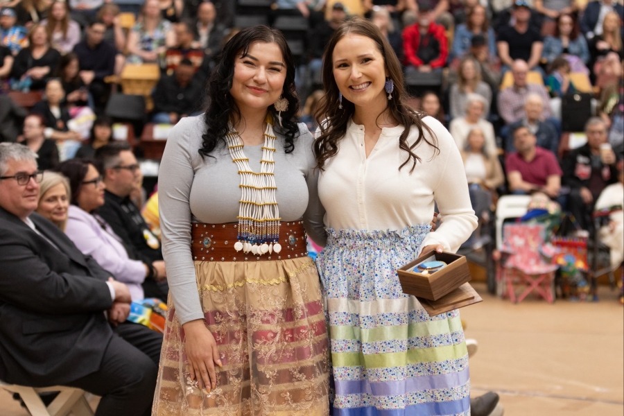 Sheri Shorting and Hope Ace stand beside each other, while Hope holds the Migizii Award.