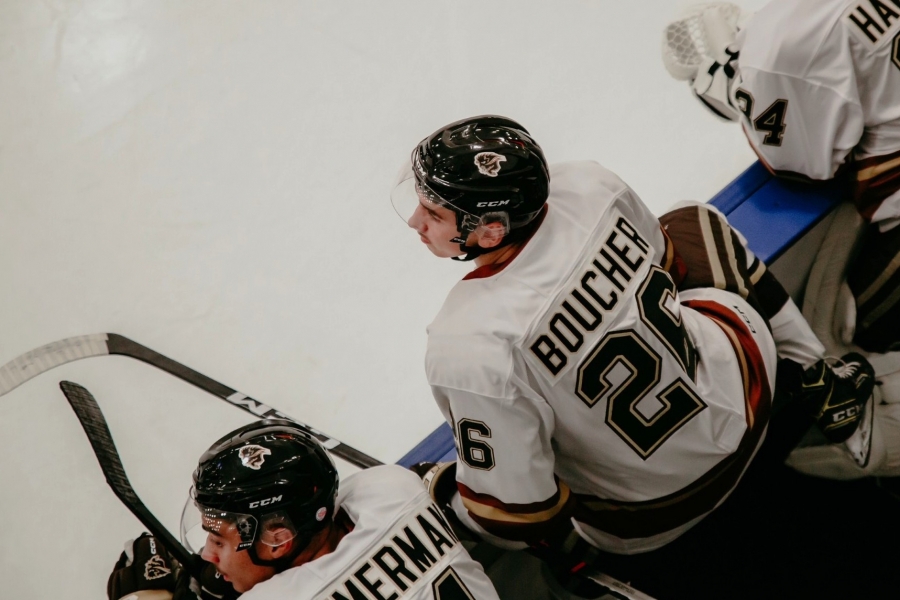 Andrew Boucher sitting in the UM Bisons team bench. His jersey letters spell BOUCHER across his back.