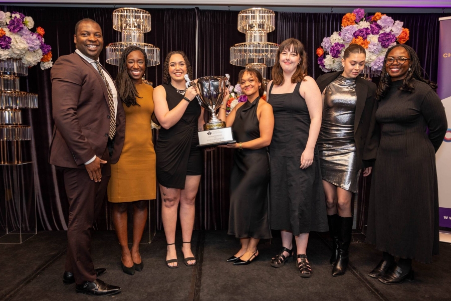 Team Manitoba and coaches hold trophies with smiles on their faces.