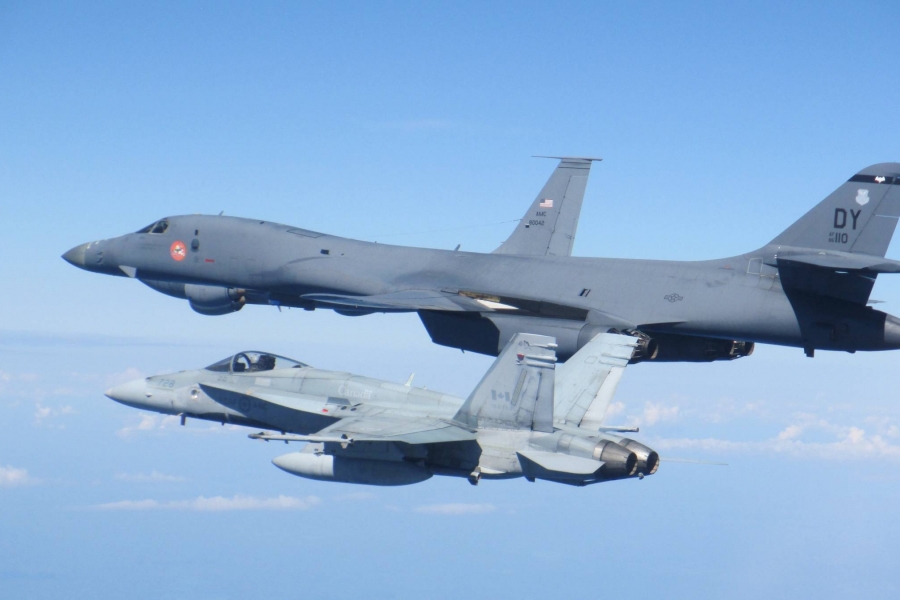 Two military aircraft in the air. 