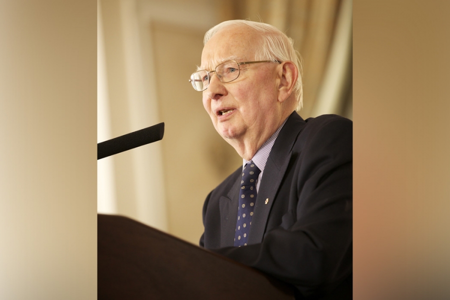 Dr. Henry Friesen speaking at a podium.