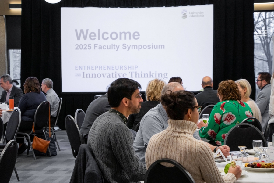 Faculty members sitting at tables at the 2025 UM Faculty Symposium.