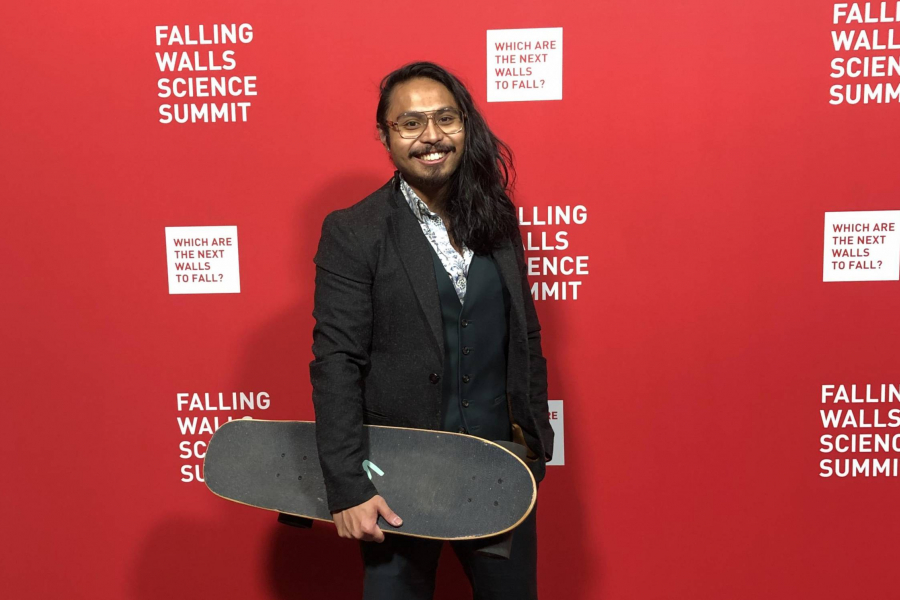 Nolan De Leon holds his signature skateboard on the red carpet at the Falling Walls Lab in Berlin.