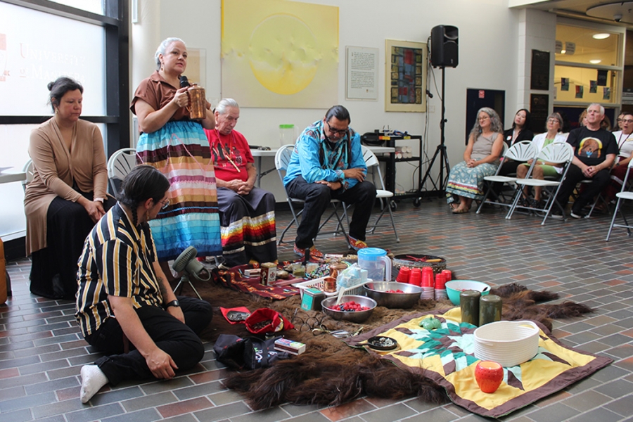 A group of Indigenous leaders around items for a water and pipe ceremony on Bannatyne campus.