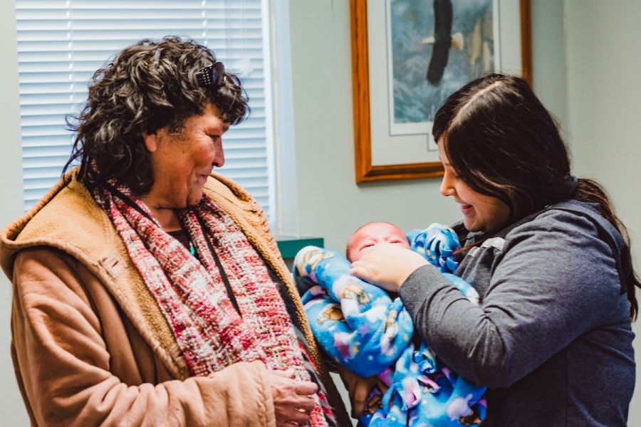 An Elder with granddaughter who is holding her baby.