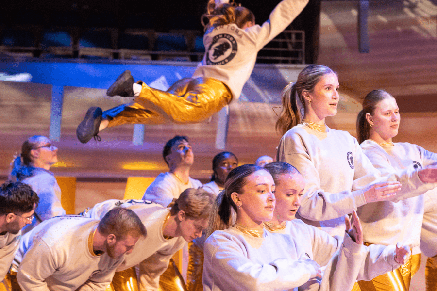 A group of students in gold lamee perform a dance routine at the 2025 Kin Games.