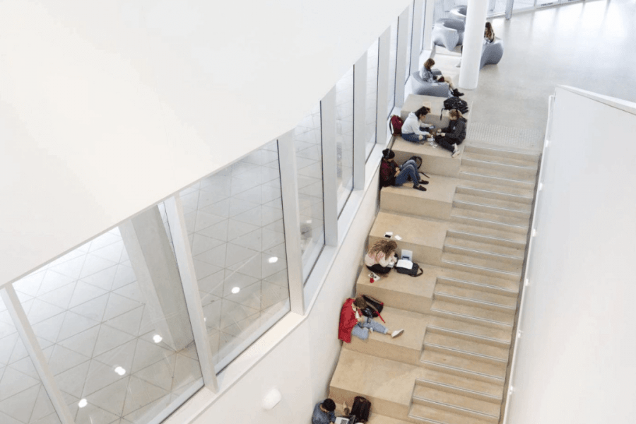 Aerial view of students sitting on the steps inside the Artlab building.