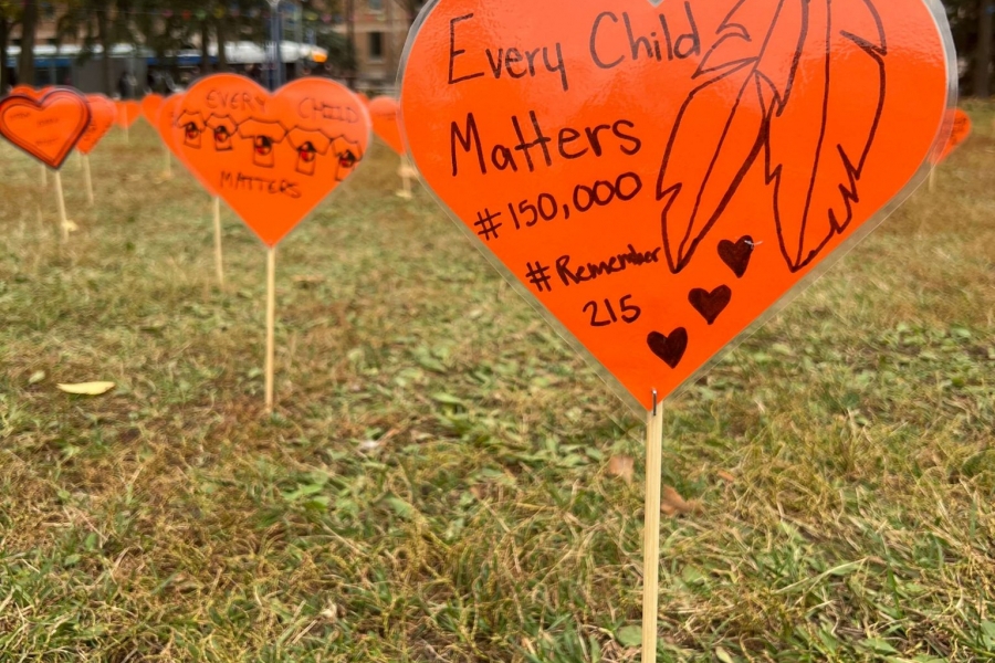 Orange paper hearts on stakes spread into the distance sharing messages of remembrance for Truth and Reconcilliation day