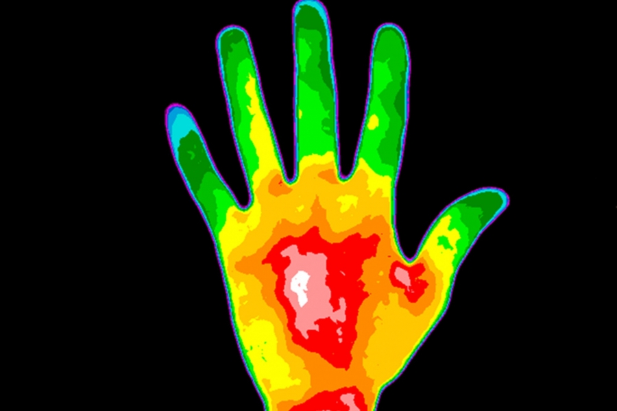 A thermal image of a human hand has glowing regions of blue, green, yellow and red.