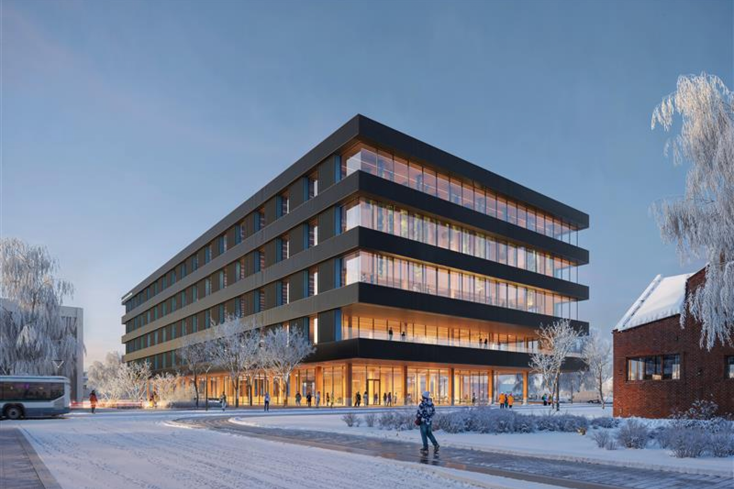 Four story building with lots of windows in the winter time at dusk
