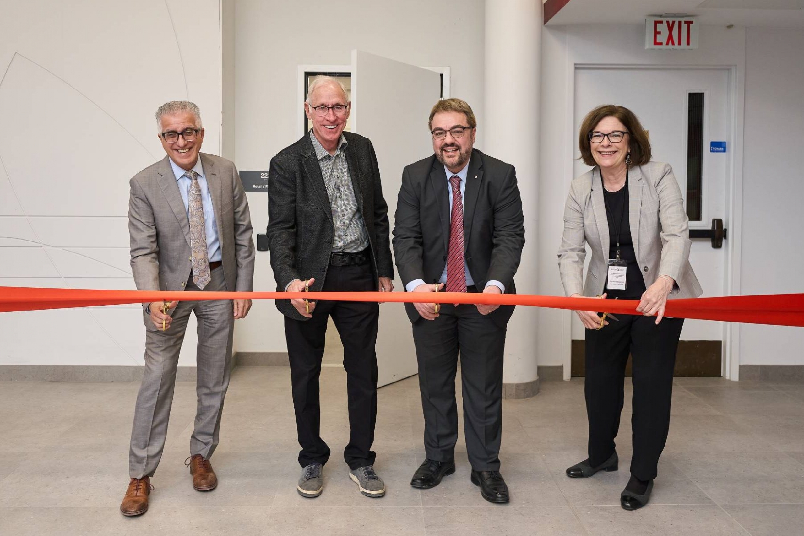 Four individuals cut a ribbon