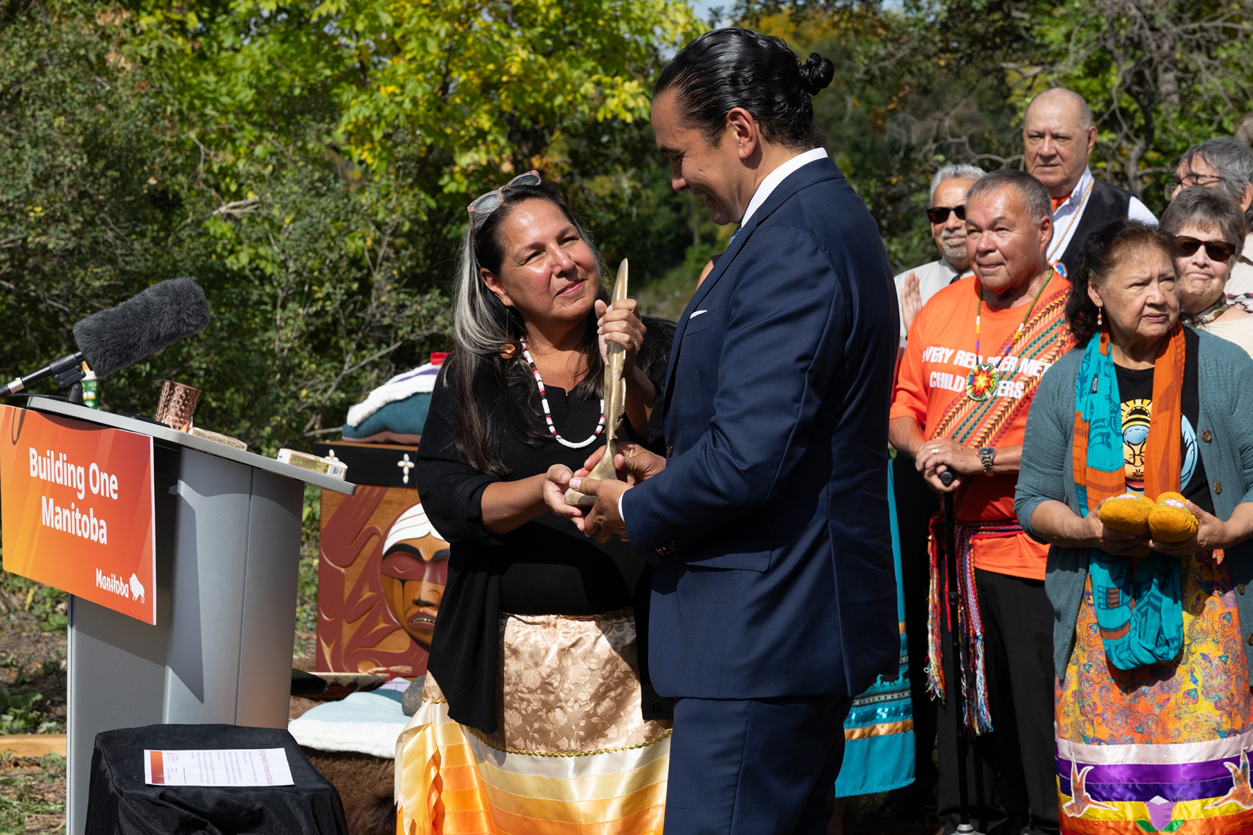 Stephanie Scott presents a gift to Premier Wab Kinew