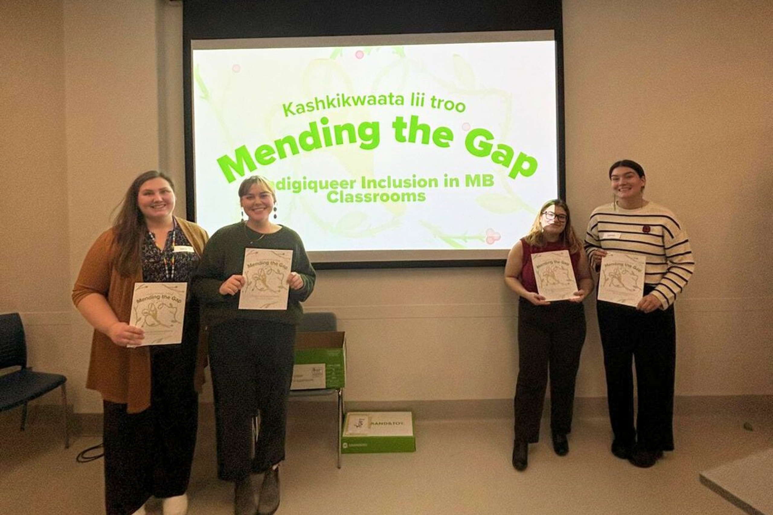 4 students stand in front of a presentation