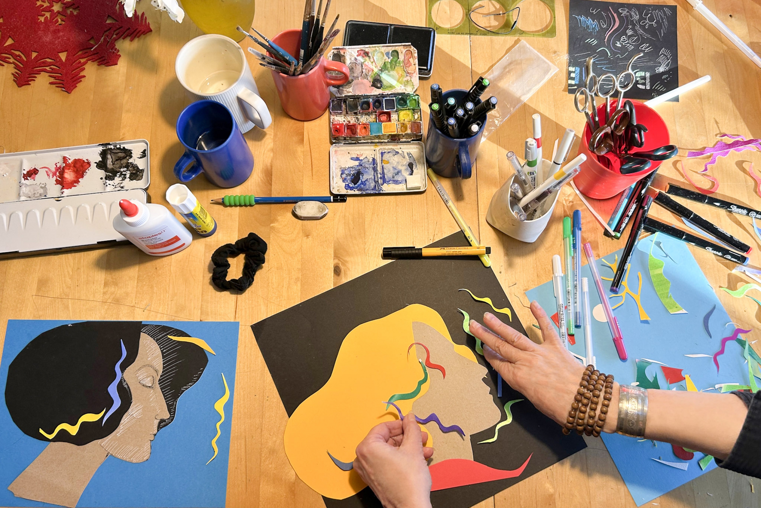 hands creating colourful imagery