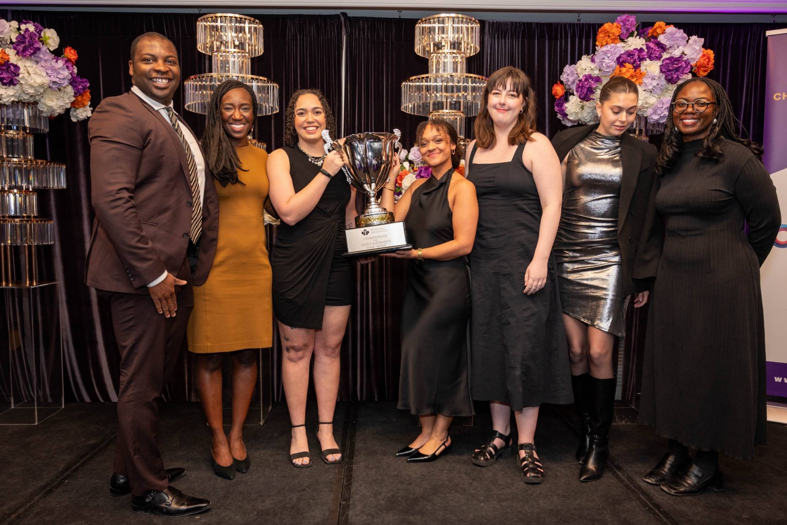 Team Manitoba and coaches hold trophies with smiles on their faces.