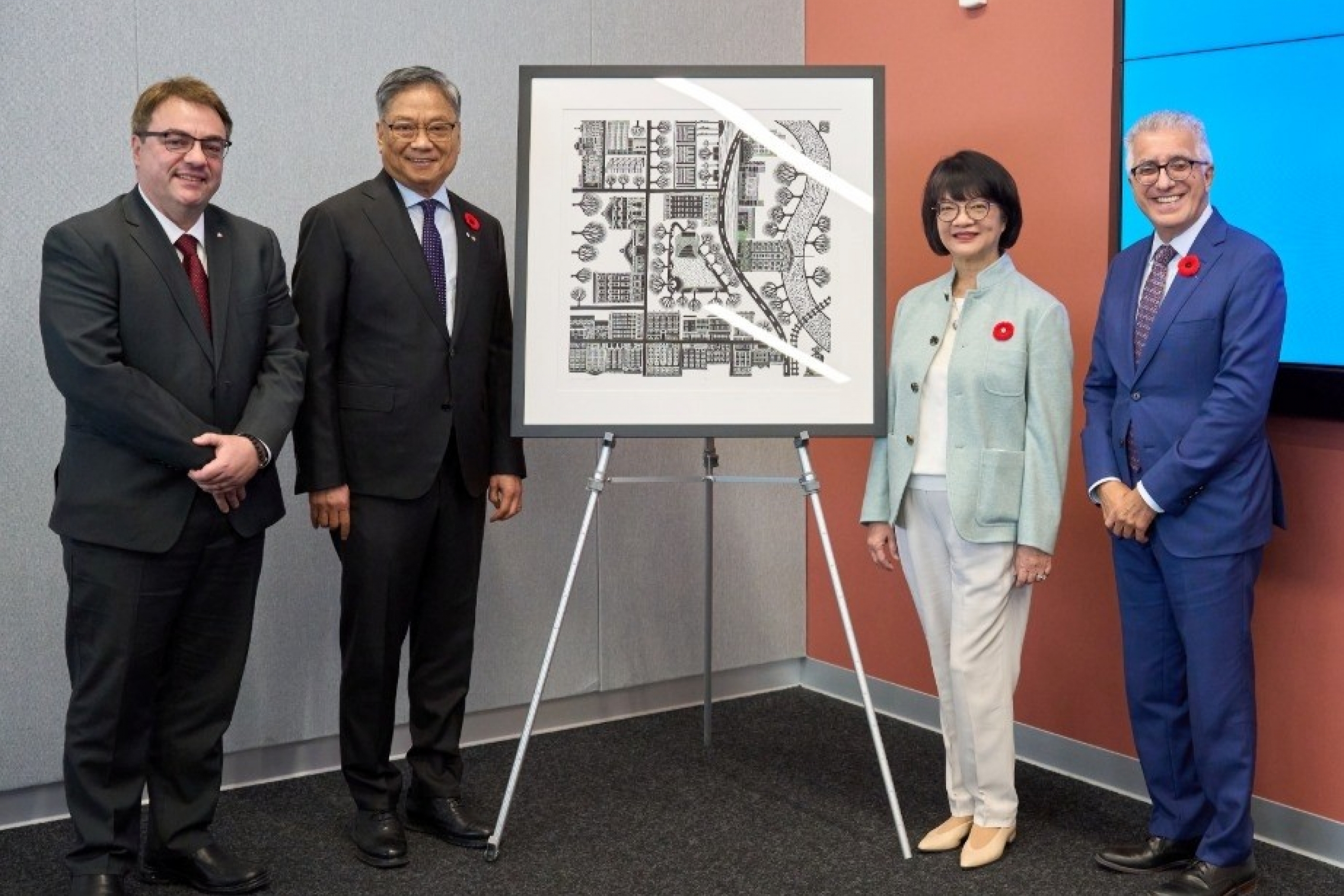 Donors pose by a framed photo gifted to them.