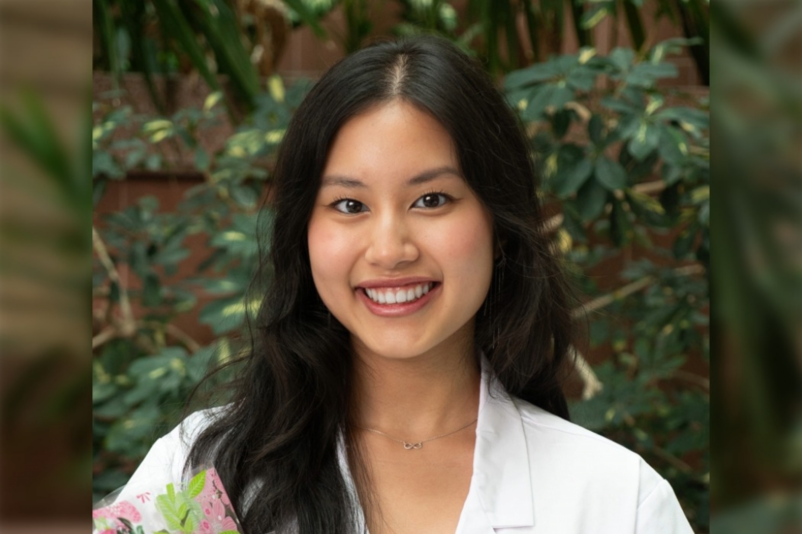 Cherry Nguyen, College of Pharmacy student in white coat, smiling at the camera.