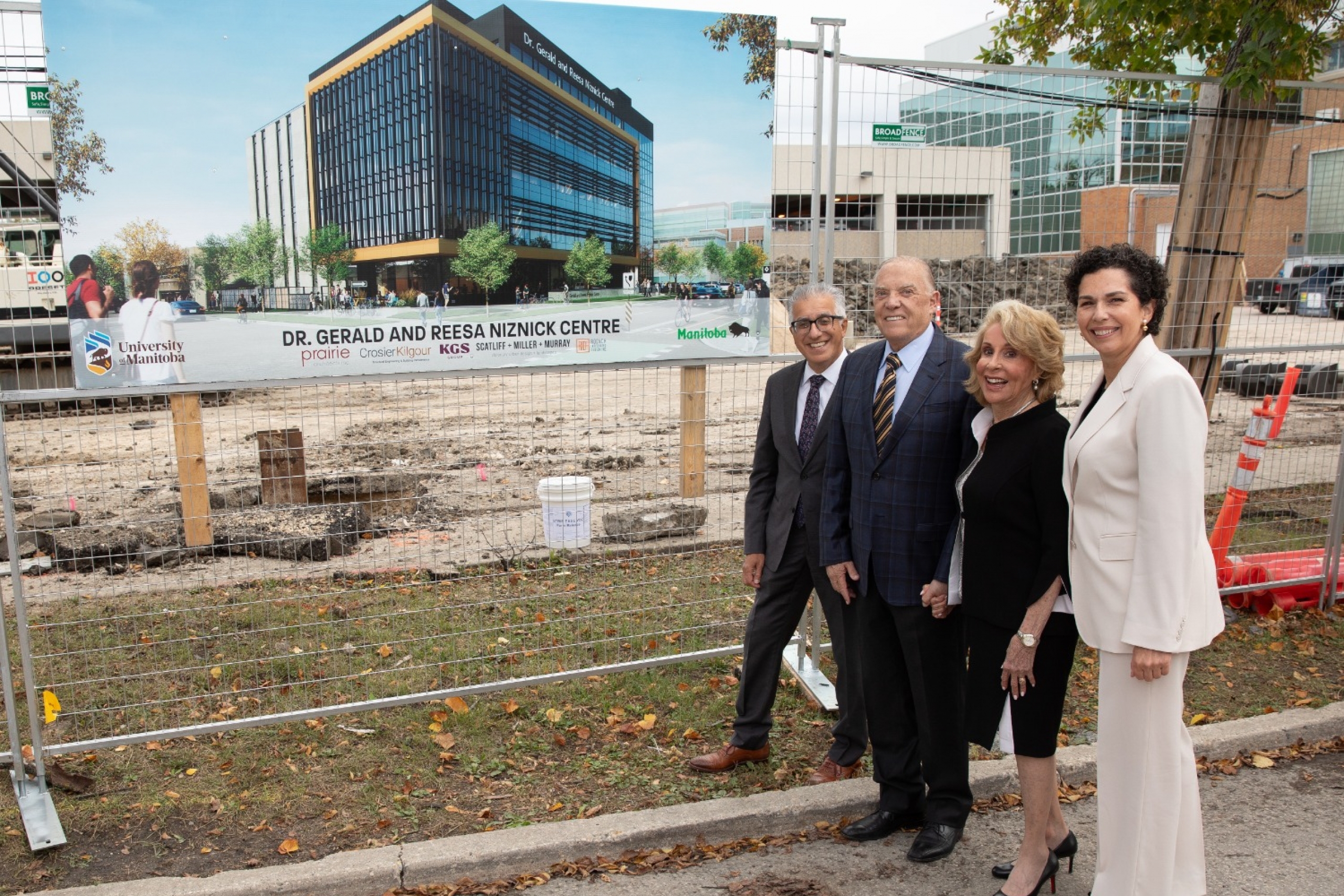 Michael Benarroch, Gerry and Reesa Niznick and Dr. Anastasia Kelekis-Cholakis stand in front of photo of rendering at construction site