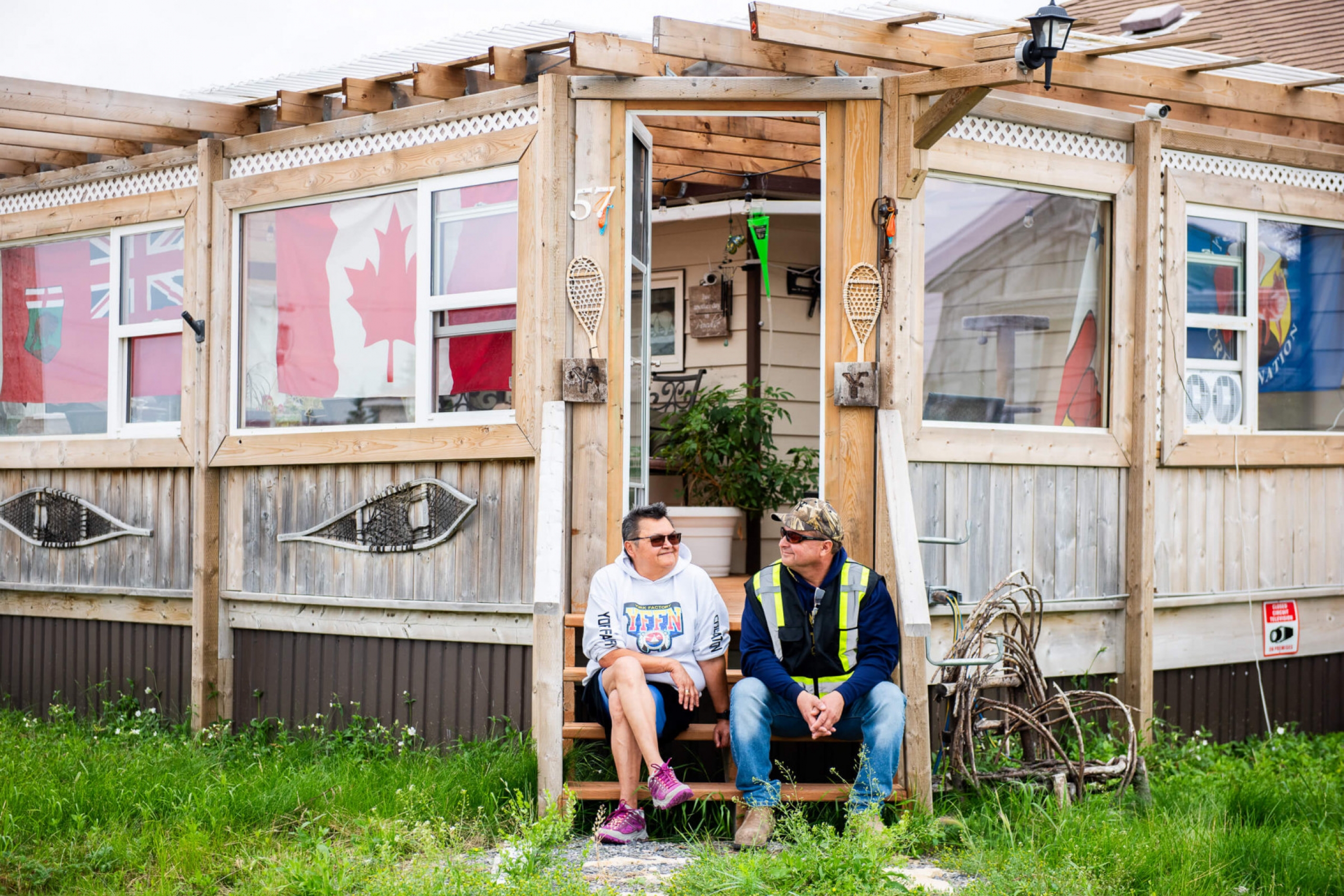 A couple sits on the steps of their home.