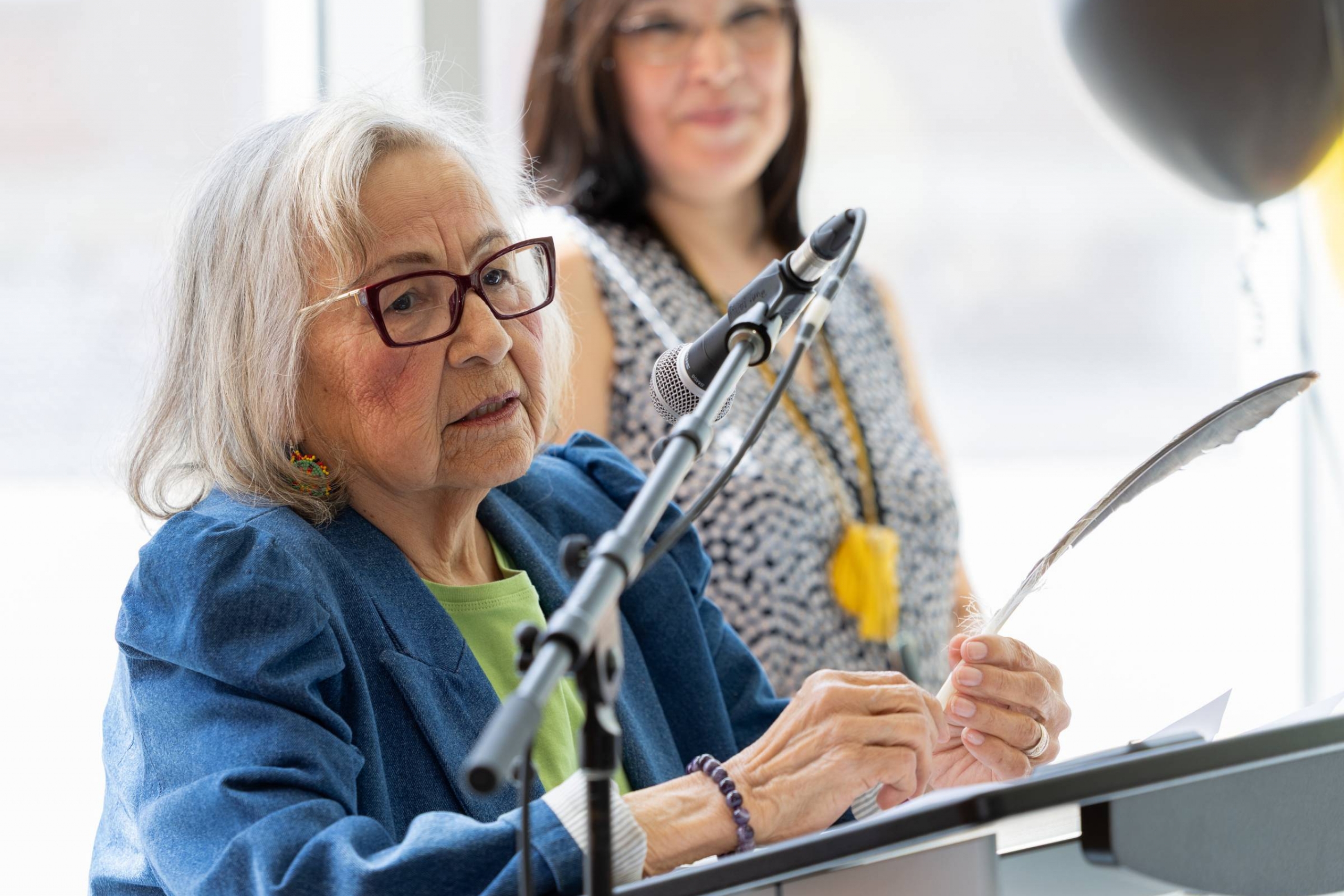 Elder Margaret Lavallee gives the opening prayer while holding an eagle feather.