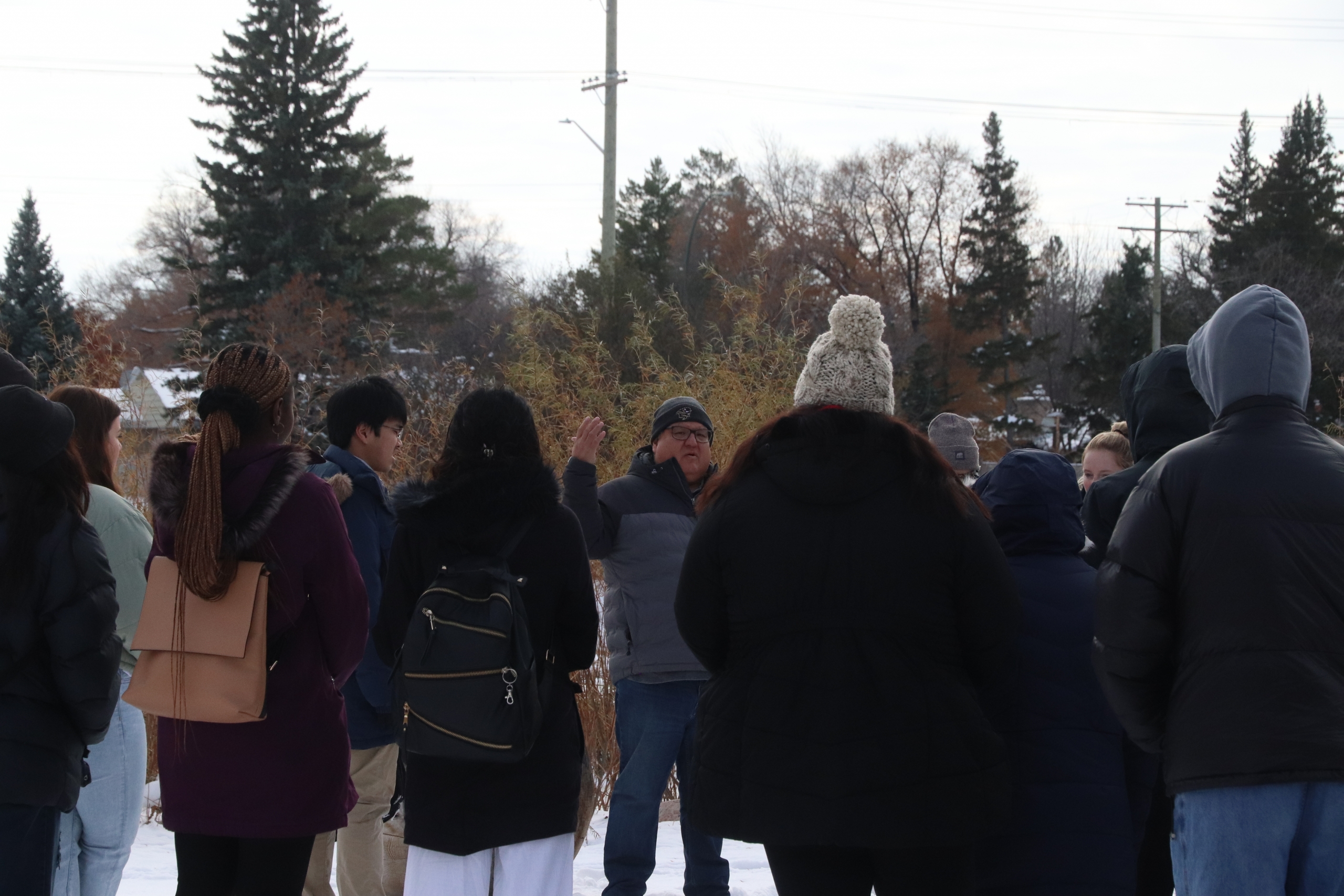 A group of students stand in the winter during an outdoor class in the Faculty of Kinesiology and Recreation Management