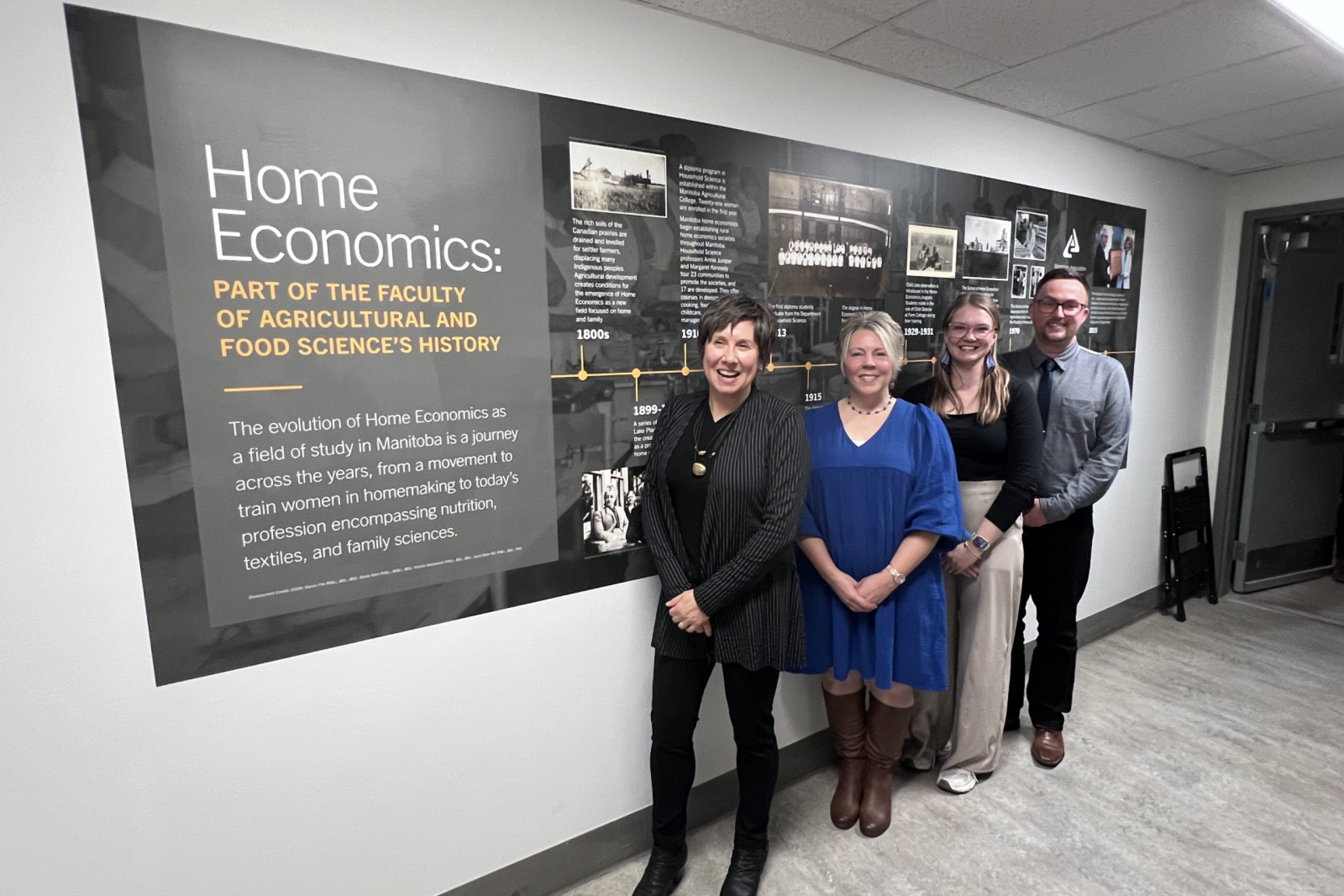 A wall mural commemorating the history of home economics. Standing in front are Joyce Slater and the three students who created it.