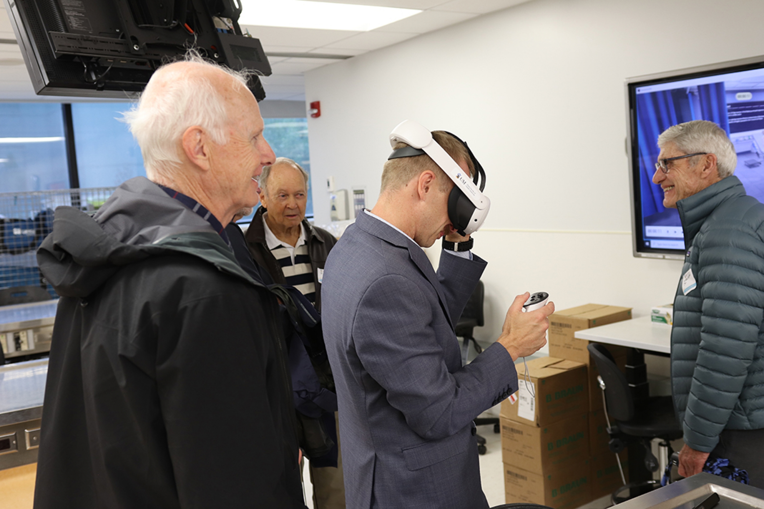 Medicine alumni watch a demonstration of virtual reality training.