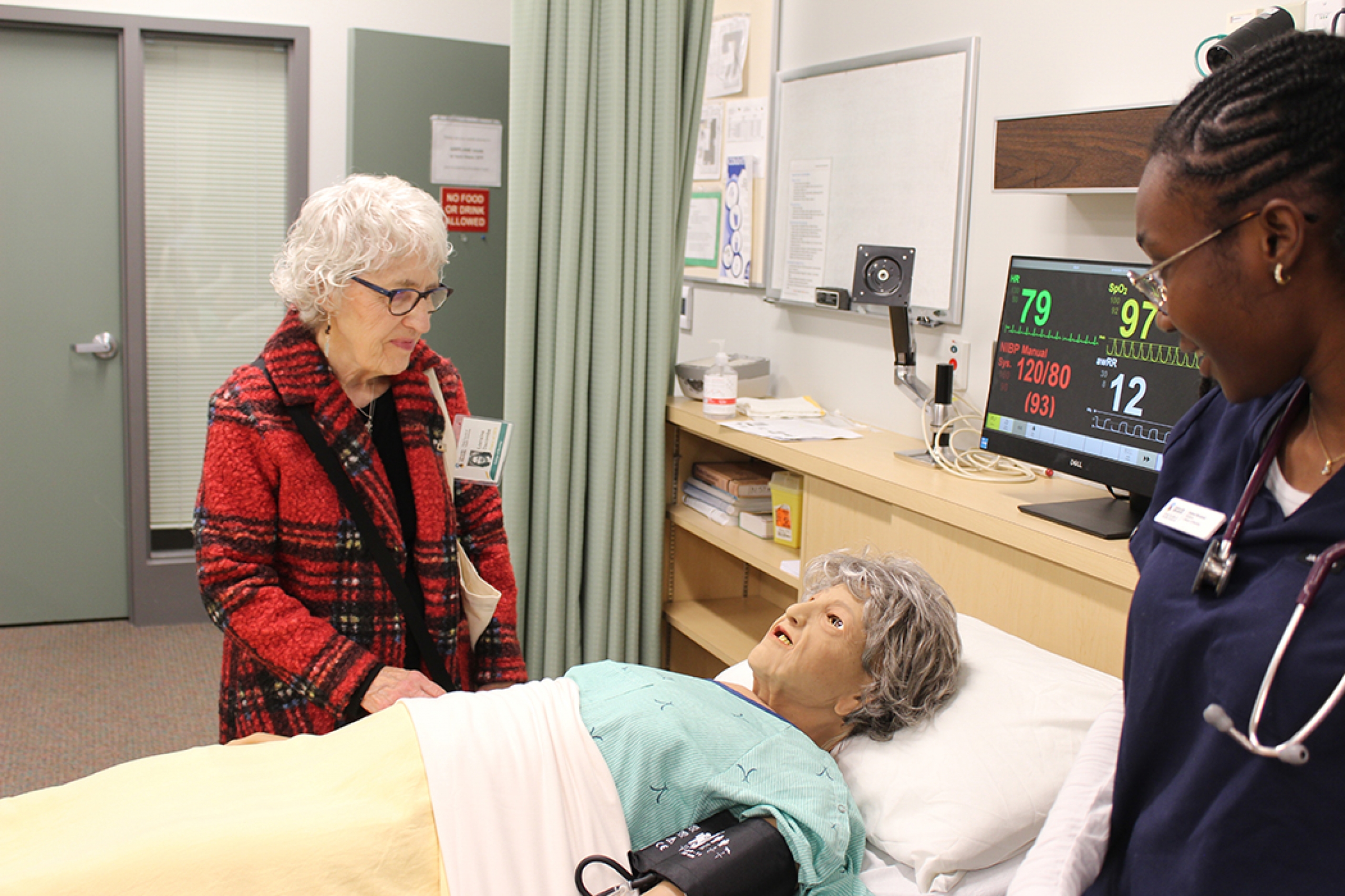 An alumna from the College of Nursing receives a demonstration of the manikins in the college's simulation lab.