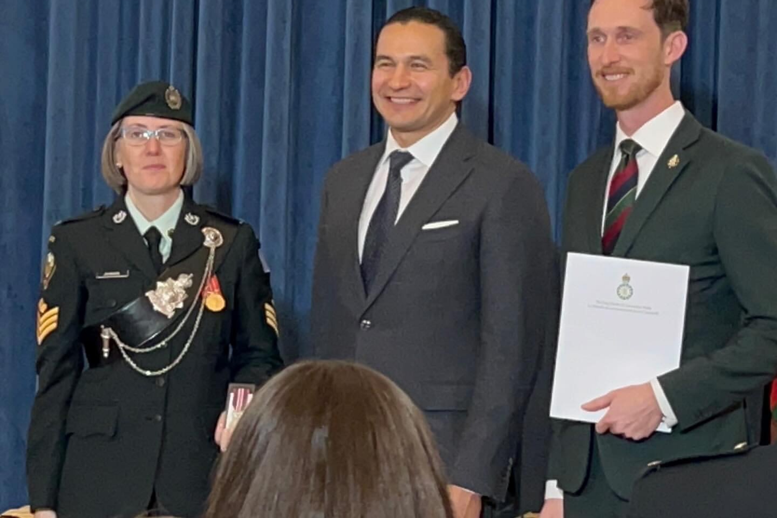 Karen Johnson in military dress receives award from premier of Manitoba
