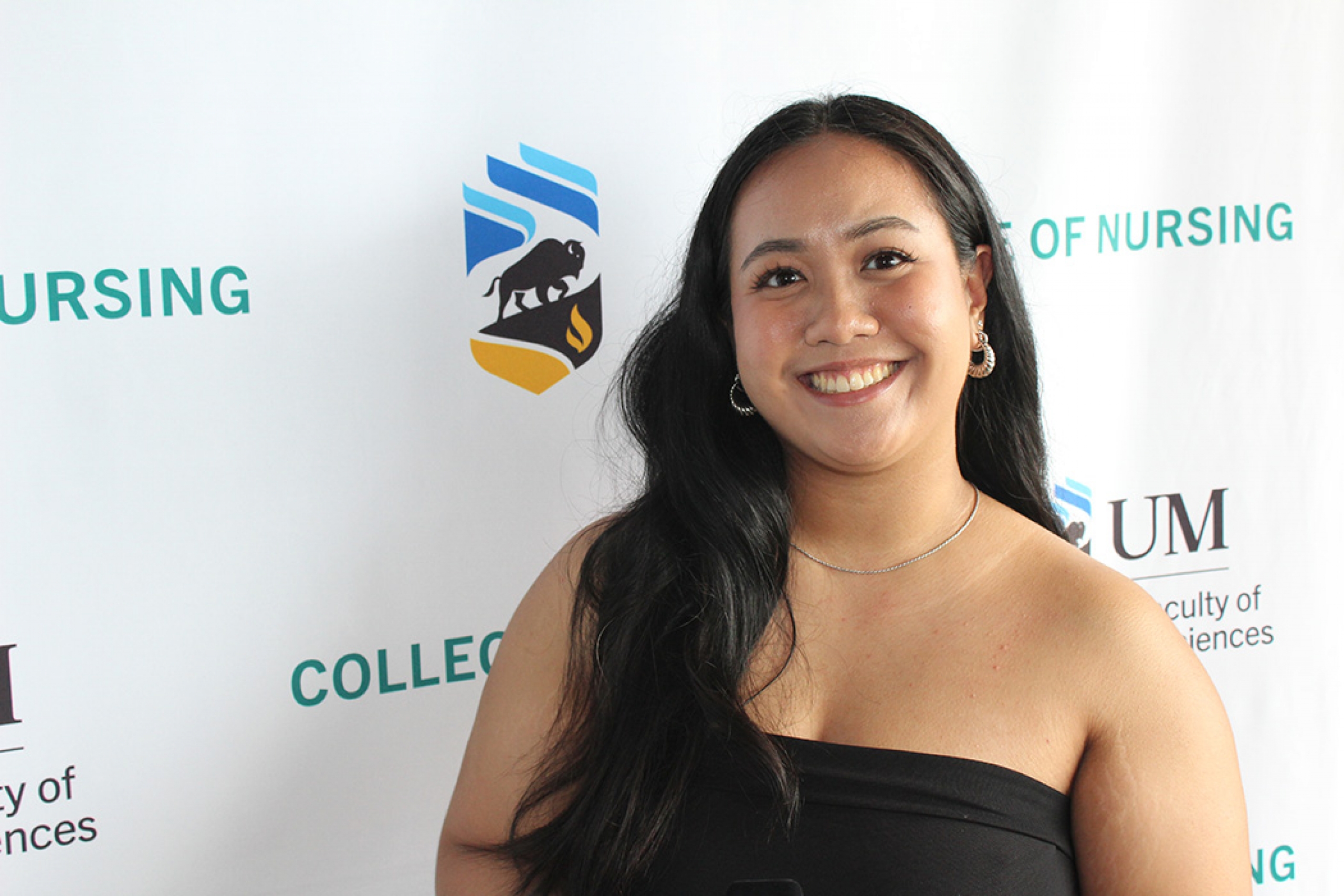 Kareena Ricafort in front of a College of Nursing banner.