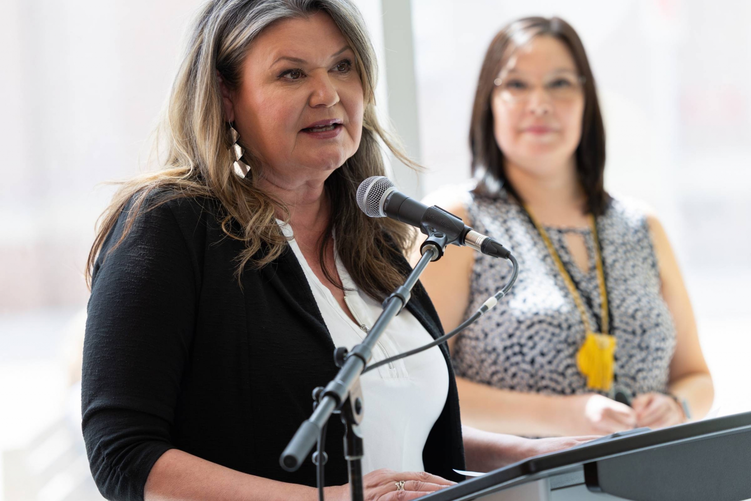 Melanie MacKinnon speaks as Kimberly Hart looks on.