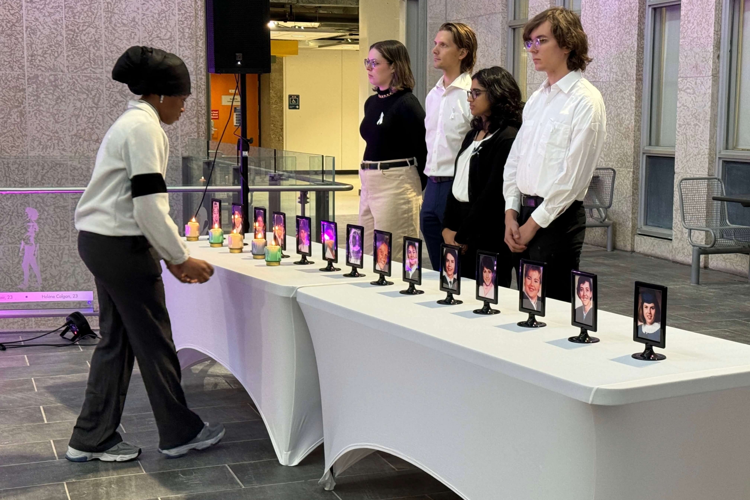 students placing candles in front of photo portraits 