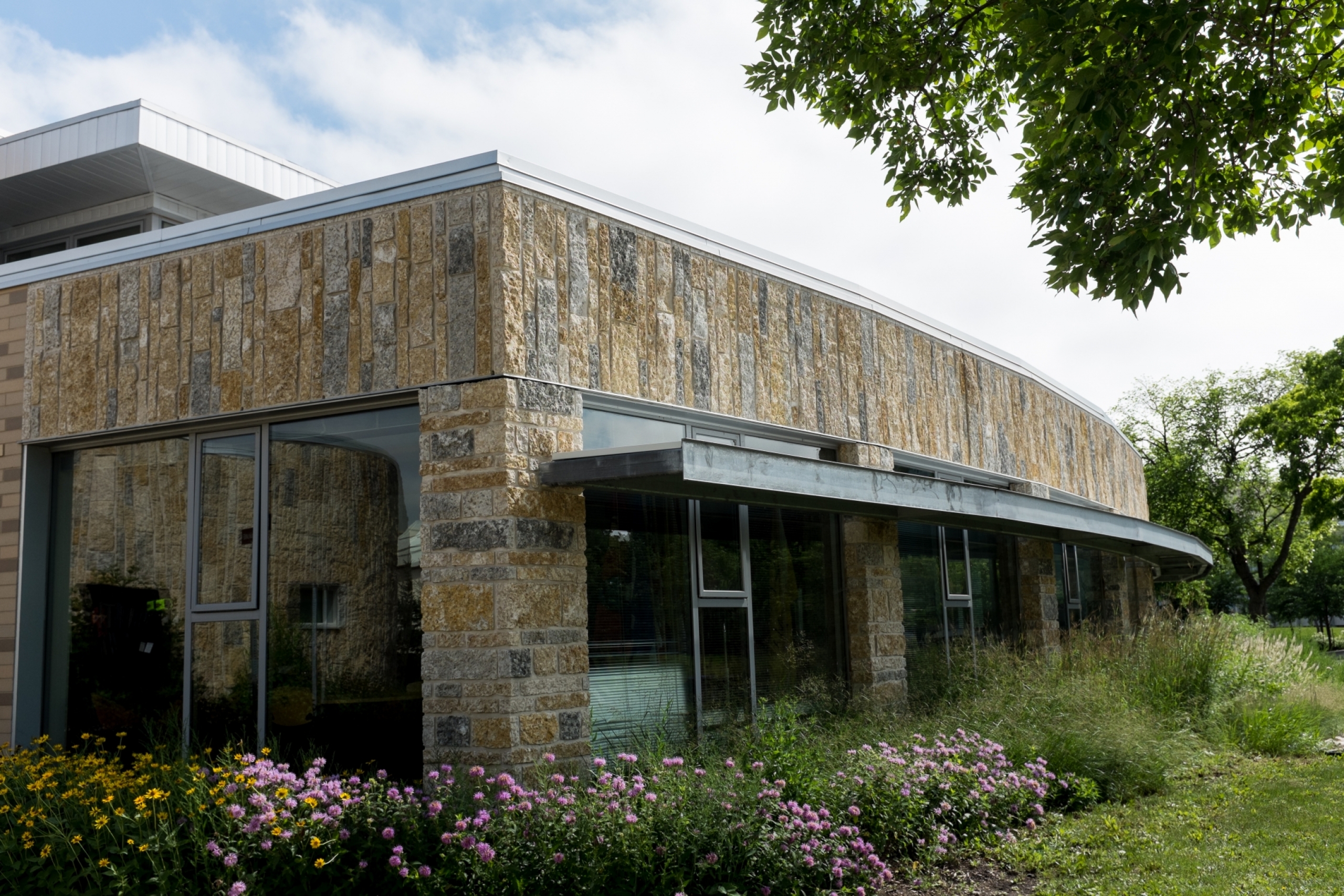 exterior of a stone building surrounded by flowers