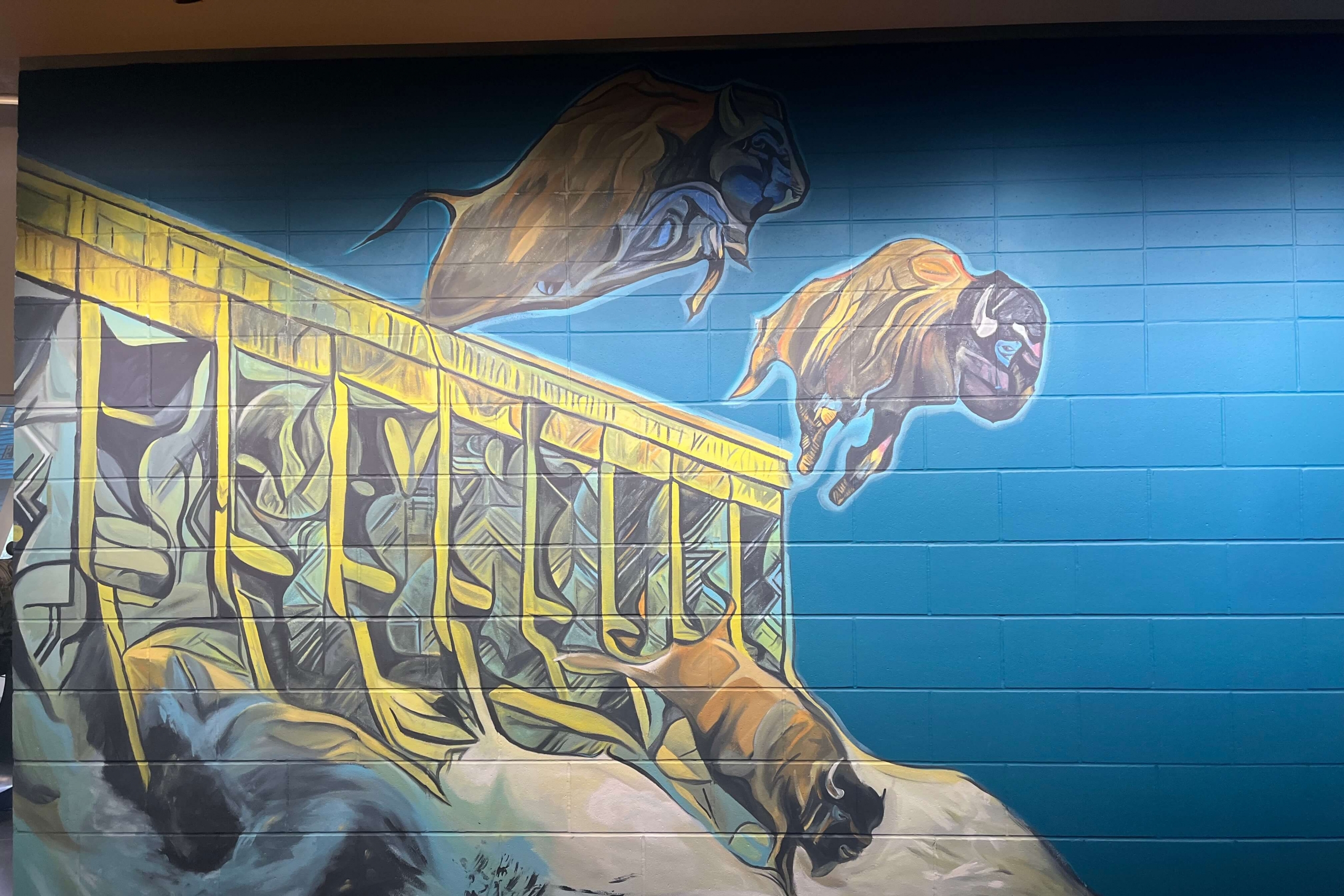 buffalo jumping off a dam in a mural