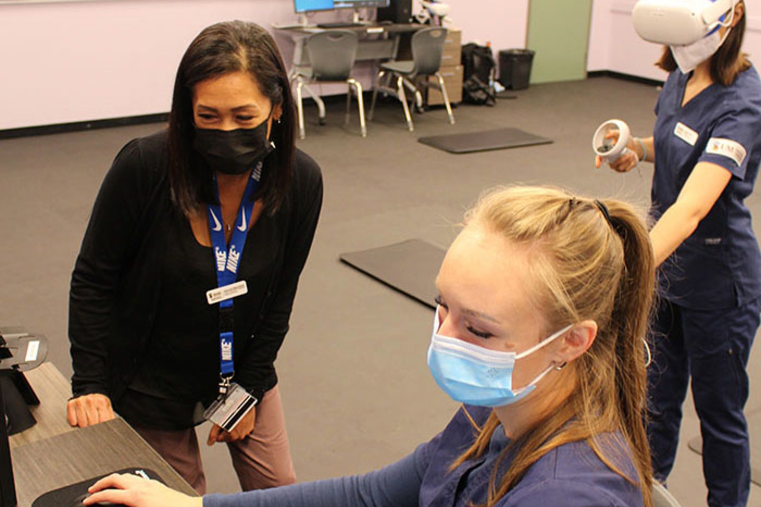 Jeanne San Miguel facilitates a VR learning session with third-year students Daria Surina and Morgan Sawchyn.